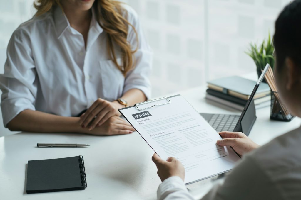 Close up view of job interview in office, focus on resume writing tips, employer reviewing good