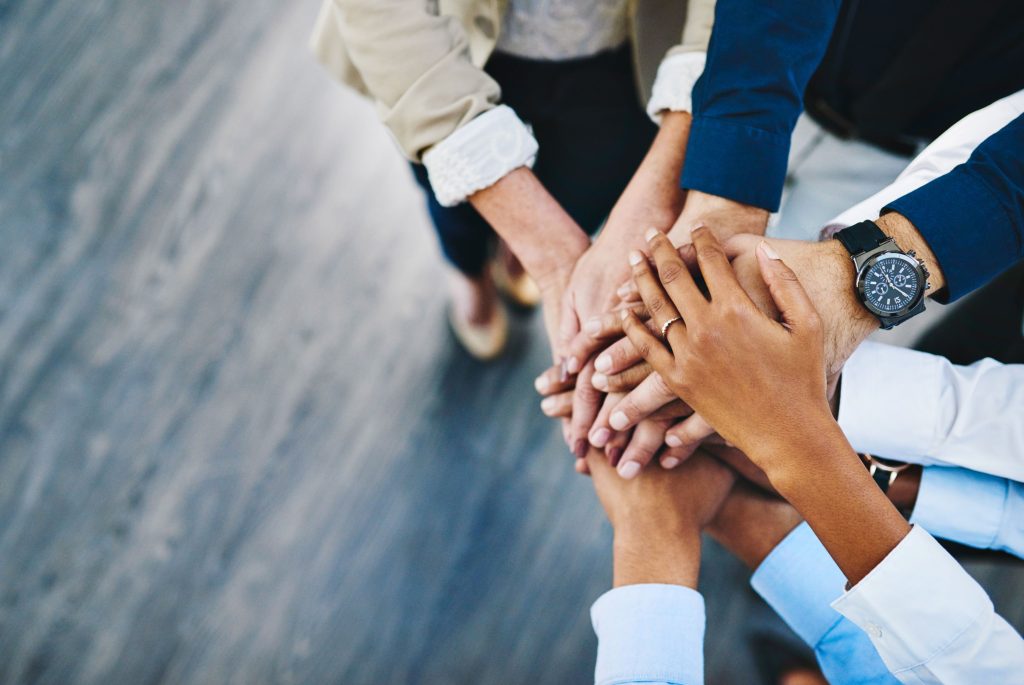 Grupo, pessoas de negócios e mãos empilhadas para trabalho em equipe, colaboração ou diversidade no ambiente de trabalho. Multidão, vista de cima ou solidariedade no escritório da empresa para compromisso da equipe, juntos para apoio.