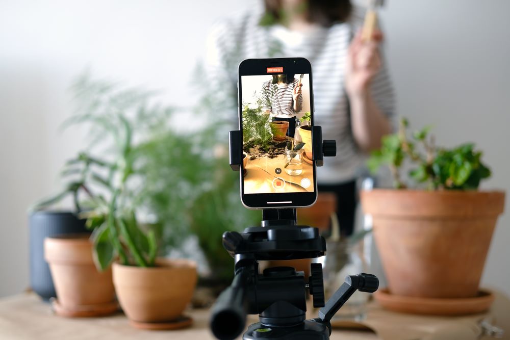 Celular gravando em cima da mesa e filmando uma pessoa